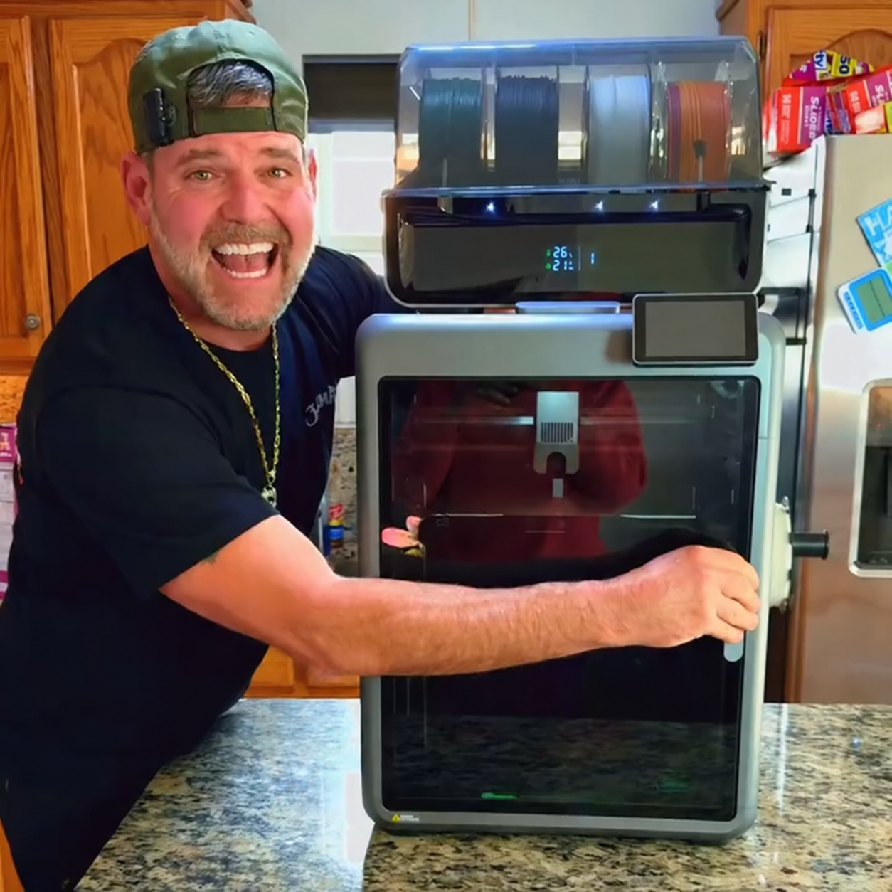 A creator smiling beside the printer and four-slot CFS, with his hand on the door.